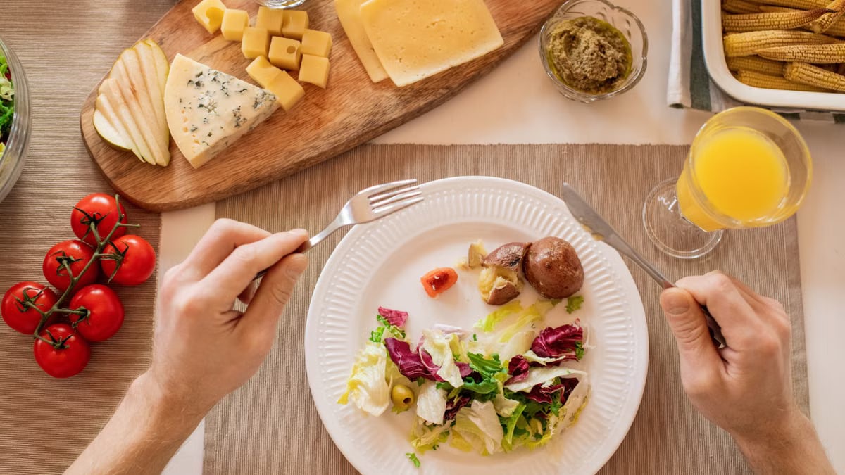 A vibrant lunch setting with salad, cheese, and orange juice, perfect for a healthy meal.