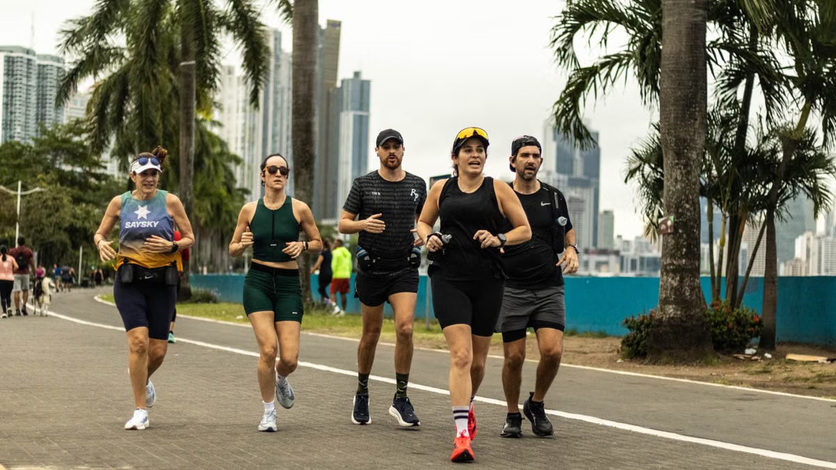 A group of diverse runners jogging along a scenic city pathway in Panama City, promoting healthy lifestyle.